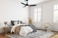Modern bedroom with a bed, rug, and ceiling fan.