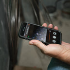 Person holding a smartphone with a screen displaying a tool app.