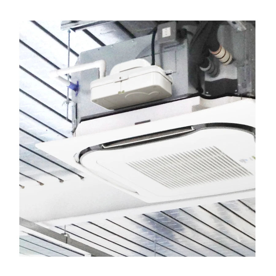 Ceiling-mounted air conditioning unit with ductwork in a room.