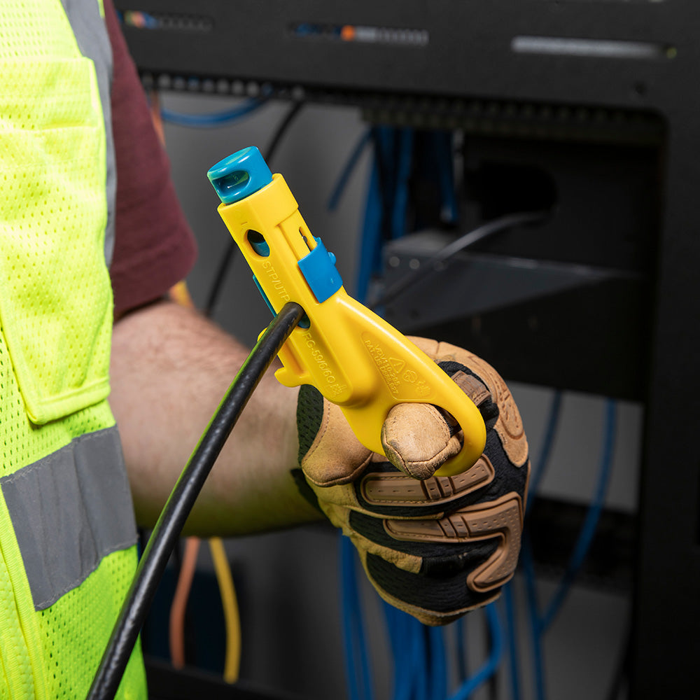 Person wearing a high-visibility vest and gloves holding a yellow tool with blue accents.