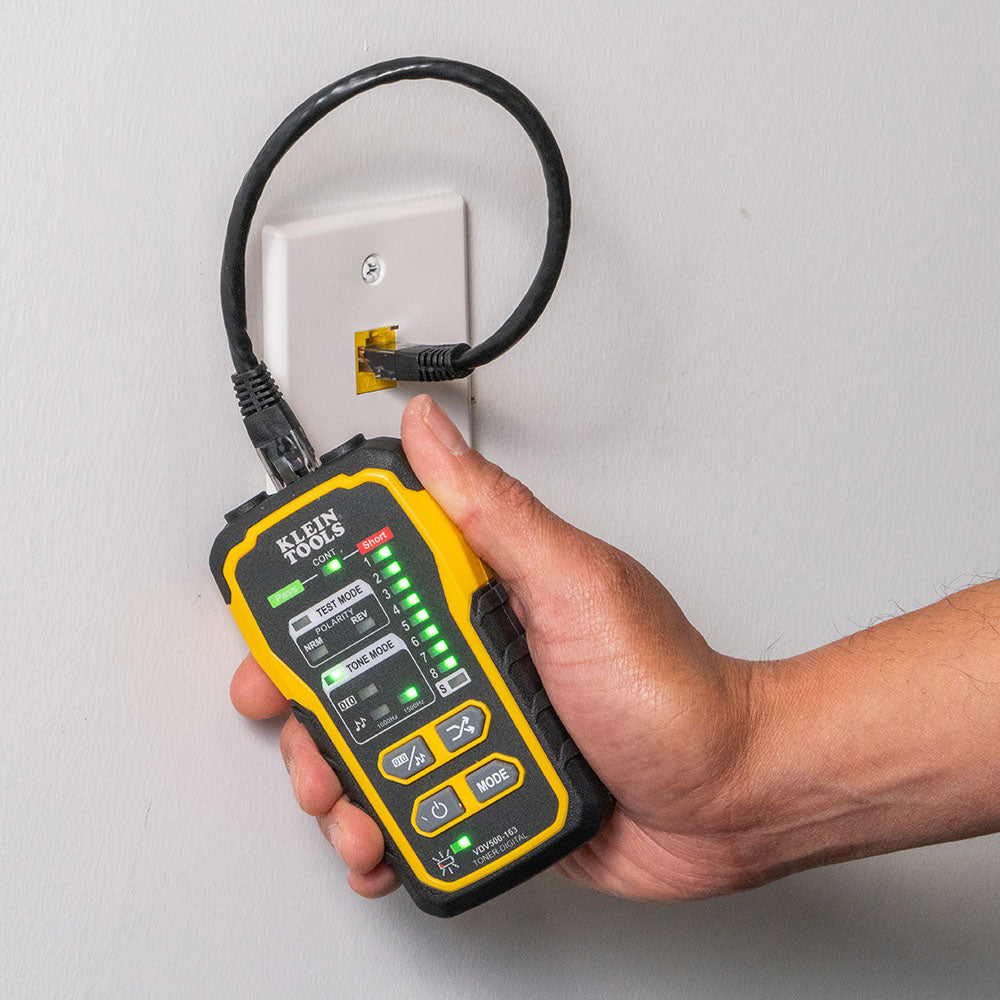 Hand holding a Klein Tools multimeter to check electrical outlet.
