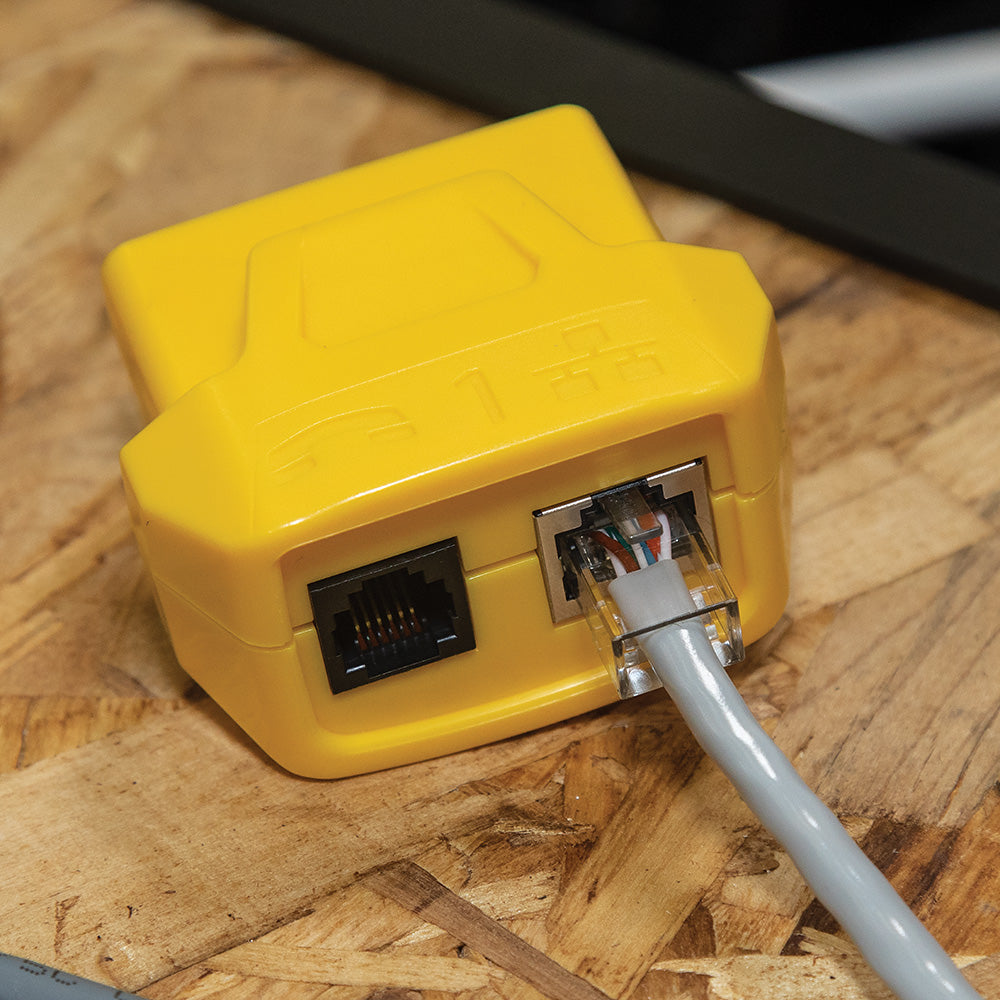 Yellow Ethernet adapter with cable on a wooden surface