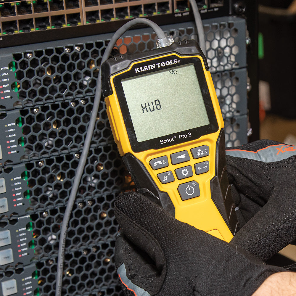 Klein Tools device with digital display held by a gloved hand against a technical background